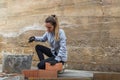 Woman bricklayer preparing laying bricks to build her own house