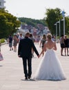 Woman in bridal gown and man in tuxedo walking on sidewalk in this tourist town after having gotten married Royalty Free Stock Photo