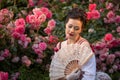 Woman bride in a ancient vintage historical dress posing in the beautiful summer rose garden