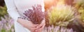 Woman bride, holding in hands bouquet of lavender flowers on background of field, close-up Royalty Free Stock Photo