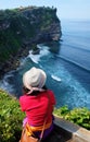 A woman admiring the beautiful Bali coastline and Uluwatu temple