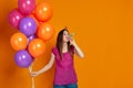 Woman with bright colorful air balloons blowing party horn Royalty Free Stock Photo