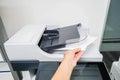 Woman bring printed documents from printer machine with left han Royalty Free Stock Photo