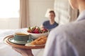 Woman Bringing Man Breakfast In Bed To Celebrate Wedding Anniversary Royalty Free Stock Photo