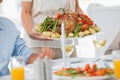 Woman brining a roast chicken in the dining room Royalty Free Stock Photo