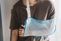 Woman with broken arm wearing an arm sling. Woman wearing an arm