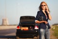 Fashion woman in sunglasses calling on phone next to broken car Royalty Free Stock Photo