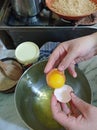 Woman broking egg to prepare cake