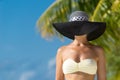 Woman with bronze tan enjoying beach relaxing joyful in summer by tropical blue water. Royalty Free Stock Photo