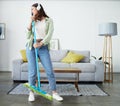 Woman, broom and singing with headphones for cleaning home, comic performance or music in living room. Girl cleaner