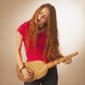 Woman with a broom styled rock guitarists (humorous photo)