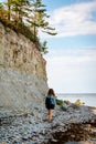 Woman with brown curly hair hiking by the Panga cliff in Saaremaa, Estonia during sunny day. The highest bedrock outcrop in