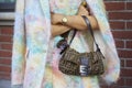 Woman with brown Fendi bag, pastel colors dress and Rolex watch before Fendi fashion show,