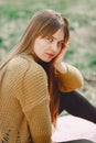 Elegant woman in a brown sweater in a spring park Royalty Free Stock Photo