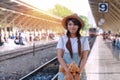 Woman with brown teddy bear standing at railroad station platform while waiting track in vacations. Portrait lady Royalty Free Stock Photo