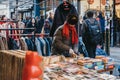 Woman browsing books at a market stall in Brick Lane, London, UK