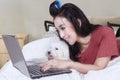 Woman browsing internet with dog on bed Royalty Free Stock Photo
