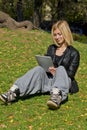 Woman browsing tablet in the park Royalty Free Stock Photo