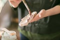 A woman with a brush paints a rim of a ceramic plate