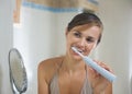 Woman brushing teeth with electric toothbrush