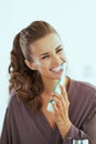 woman brushing teeth with electric toothbrush in bathroom Royalty Free Stock Photo