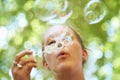 Woman, bubbles and blowing outdoor for fun on weekend, break or holiday for relax and summer entertainment. Person