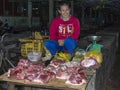 Woman bucher selling meat at the market.