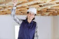 woman in builder hardhat and uniform installing suspended ceiling