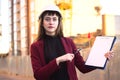 Woman builder holding blueprints, clipboard. Smiling architect girl in helmet at building background Royalty Free Stock Photo