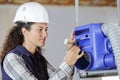 Woman builder instaling cooling system