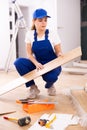 Woman builder preparing laminated boards for laying floors