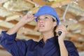 woman builder in protective clothes at construction site walkie-talkie