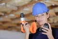 Woman builder putting driller battery Royalty Free Stock Photo