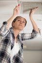 woman builder with screwdriver on ladder