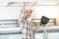 woman in builder uniform installing suspended ceiling