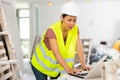 Woman builder using laptop in construction site