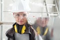 Woman builder work with the straightedge spirit level, wearing helmet, safety glasses and hearing protection headphones,