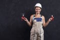 Woman builder worker in uniform holds wirecutter. Electrician female in helmet. Professional electric engineer.