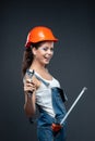 Woman builder worker with wrench standing against grey background Royalty Free Stock Photo