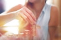 Woman building money column in sunset closeup