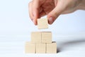 Woman building pyramid of cubes on white background, closeup with space for text. Idea concept Royalty Free Stock Photo