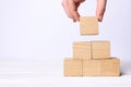 Woman building pyramid of cubes on white background, closeup with space for text. Idea concept Royalty Free Stock Photo