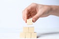 Woman building pyramid of cubes on white background, closeup with space for text. Idea concept Royalty Free Stock Photo