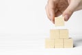 Woman building pyramid of cubes on white background, closeup with space for text. Idea concept Royalty Free Stock Photo