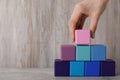 Woman building pyramid with wooden cubes at table, closeup and space for text. Management concept Royalty Free Stock Photo