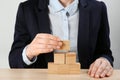 Woman building pyramid at table, closeup. Career promotion concept Royalty Free Stock Photo