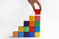 Woman building stairs with colorful cubes on background, closeup. Career promotion concept