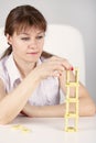 Woman builds precarious tower of dominoes
