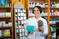 Woman with bunch of dried herbs in drugstore