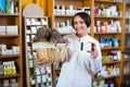 Woman with bunch of dried herbs in drugstore